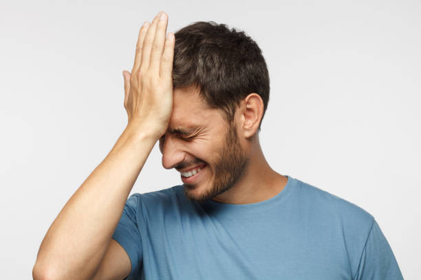 Face palm concept. Stressed out young guy making facepalm gesture with hand.